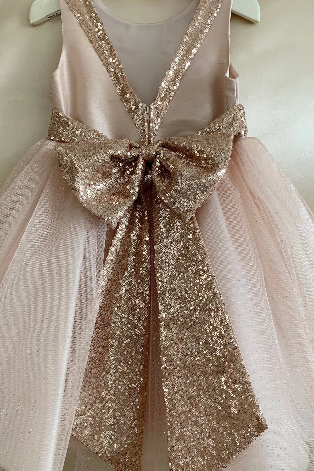 Pink flower girl dress with a large sequin bow.