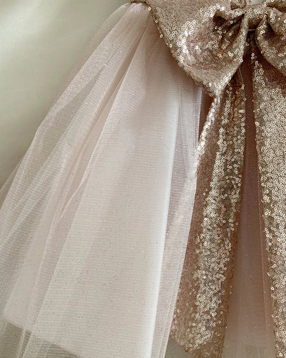 Bodice close-up highlights decorative bow with tulle and sequins. Rose Gold Flower girl dress.