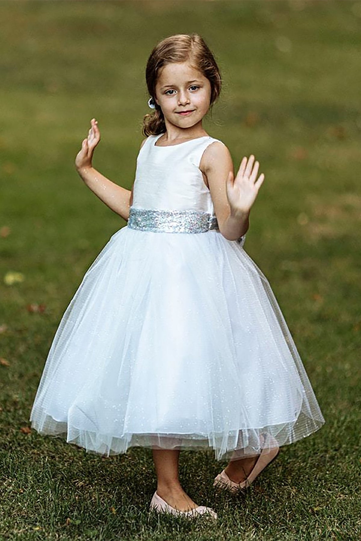 A white flower girl dress with a silver belt.