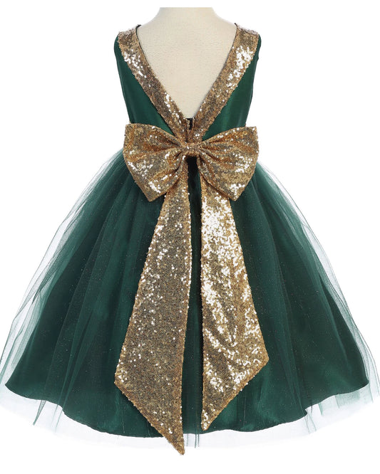 Green dress with a large gold sequin bow on a mannequin against a white background