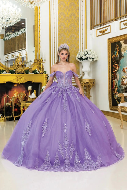 Woman standing front-facing in lilac quinceañera ball gown with off-shoulder floral appliqué sleeves, sheer corset bodice, embroidered skirt accents, and voluminous elegant silhouette