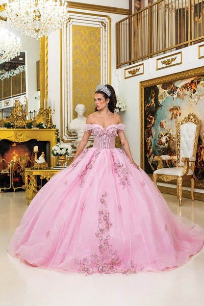 Woman standing front-facing in pink quinceañera ball gown with off-shoulder beaded fringe sleeves, sheer corset bodice, 3D floral appliqués, and glitter tulle layered skirt