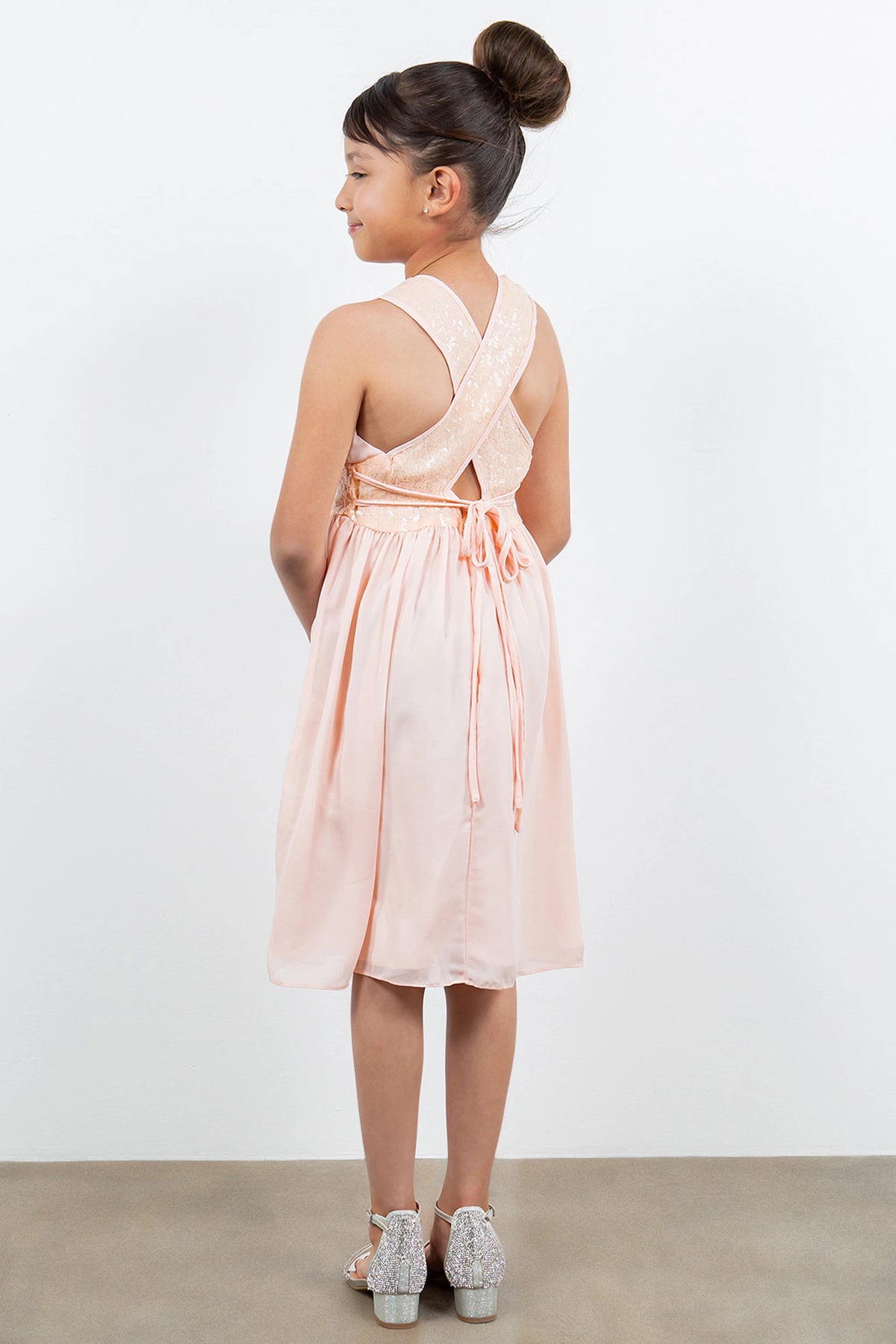 Finished details of crossed sequin-trimmed back straps distinguish the Blush kids party dress.
