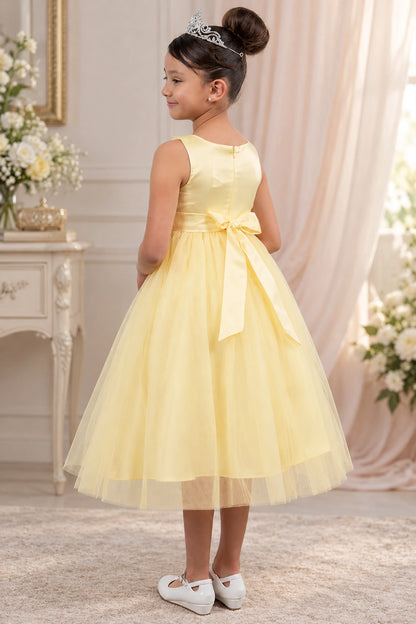 The back of this Champagne flower girl dress features a satin bodice and a tied waist bow.