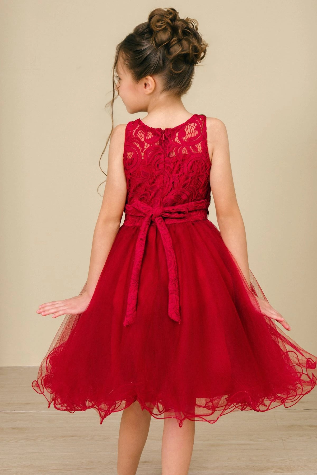 Showcasing with a lace back and satin bow, this Burgundy kids party dress displays elegant detail.