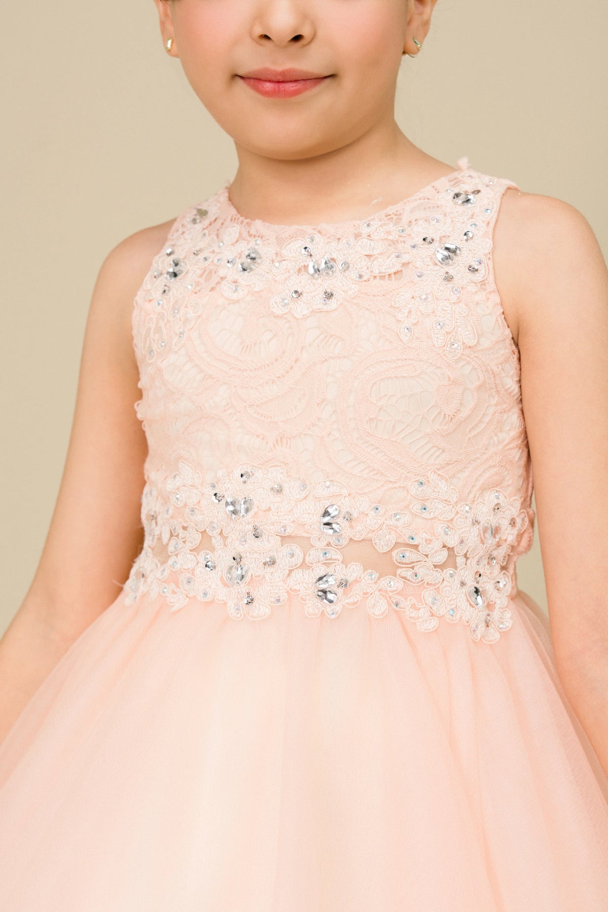 Accented beaded floral lace on the bodice adds character to this Peach kids party dress.