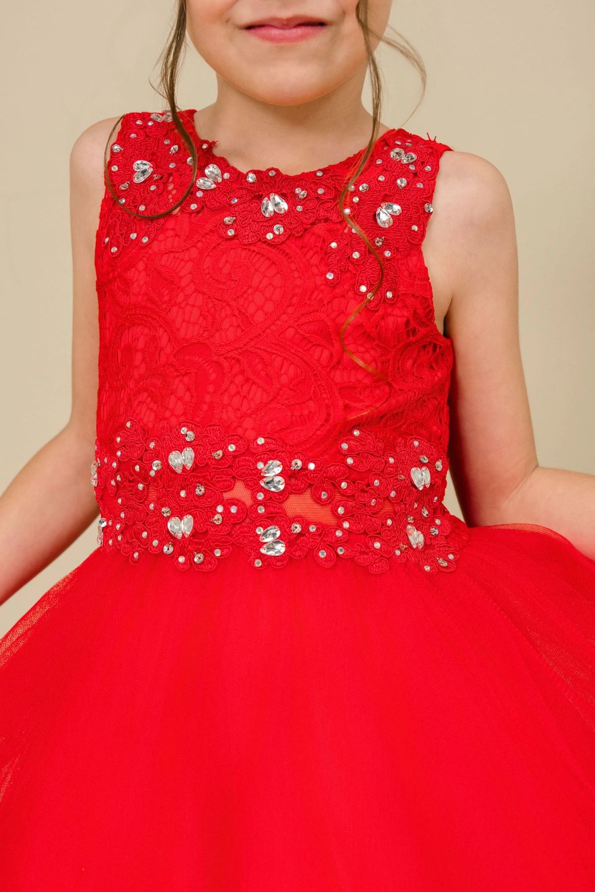Detailed by beaded floral lace on the bodice, the Red kids party dress reveals its construction.