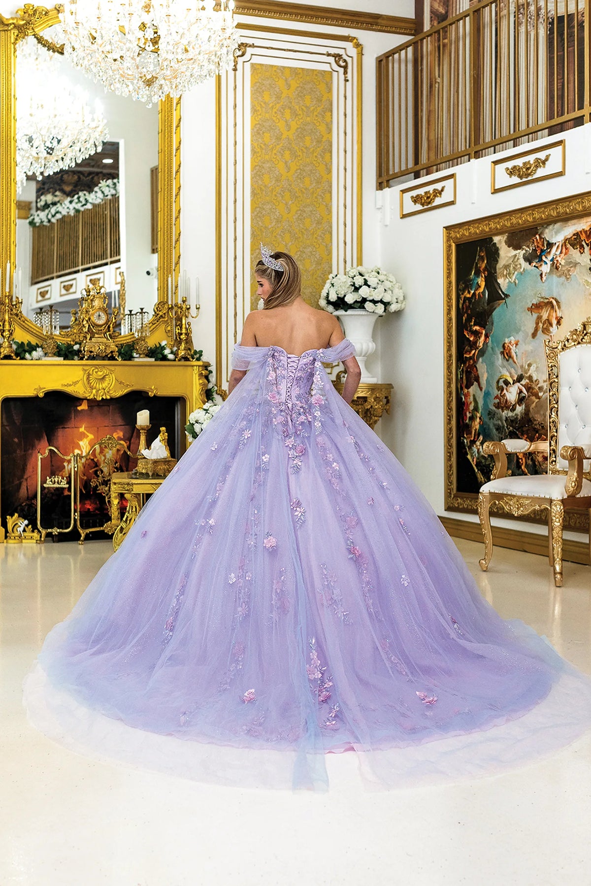 Back view of a Bahama/Lilac quinceañera gown showing lace-up back, puff sleeves, and 3D floral appliqués