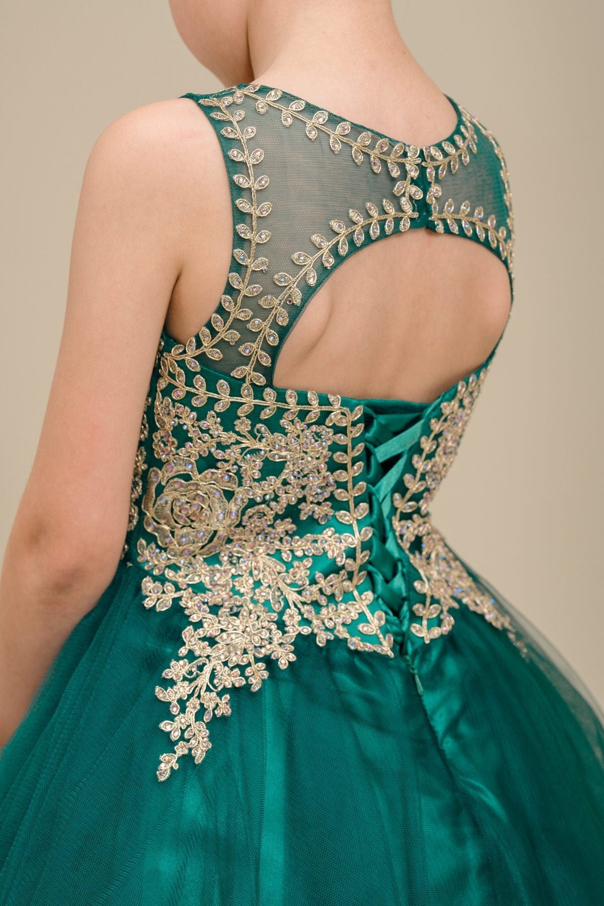 Close-up back view of hunter green flower girl dress showing floral applique and pearl detail.