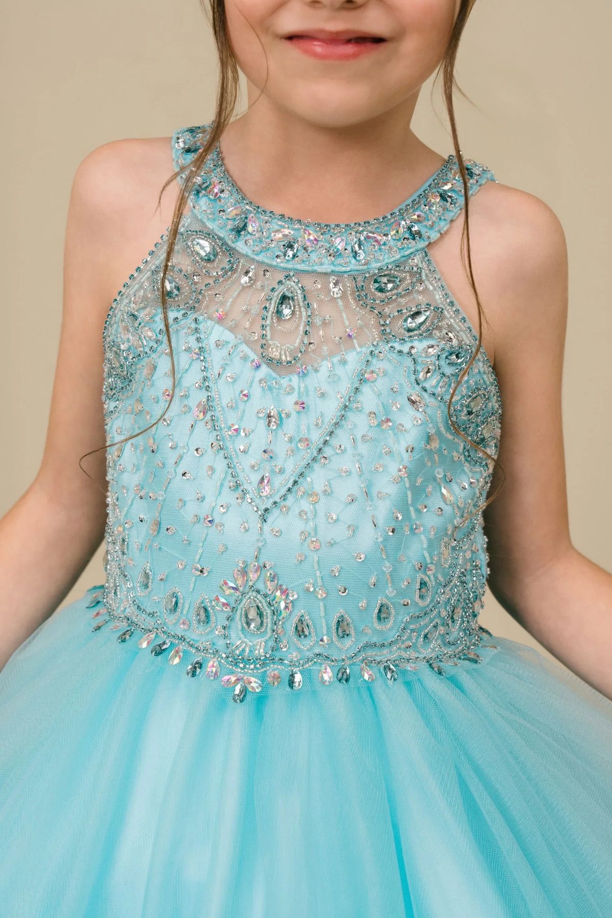 Detailed by crystal beading across the bodice, the Aqua kids party dress reveals its construction.