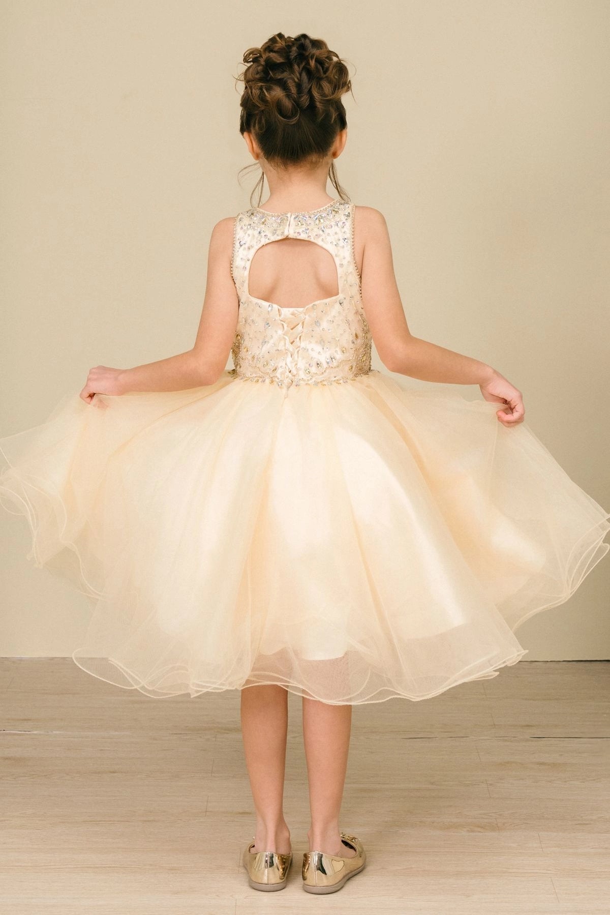 Finished details of a beaded keyhole back distinguish the Champagne kids party dress.