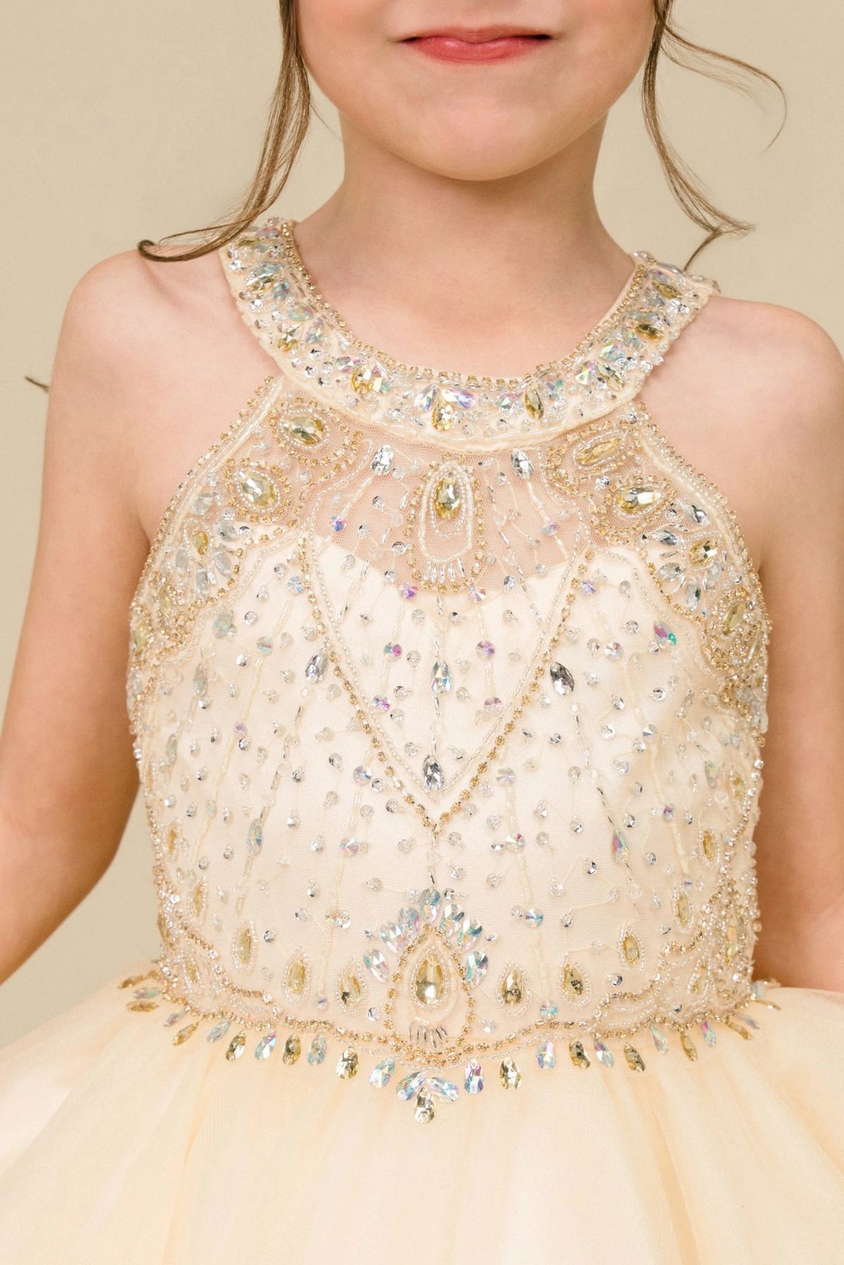 Detailed by crystal beading across the bodice, the Champagne kids party dress reveals its construction.