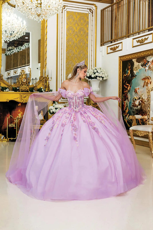 Woman standing front-facing in lilac quinceañera ball gown with off-shoulder sleeves, corset bodice, floral embroidery, glitter tulle overlay, and detachable sheer cape