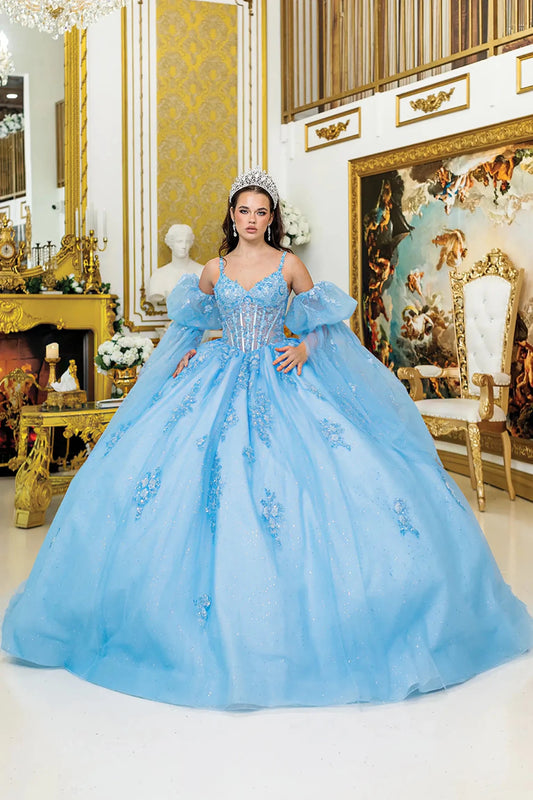 woman wearing bahama blue quinceañera dress. it is sweetheart corset, puff sleeves, floral and glitter tulle skirt