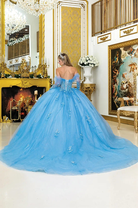 Woman in a blue quinceanera sweet heart gown standing in an opulent room with gold decor.