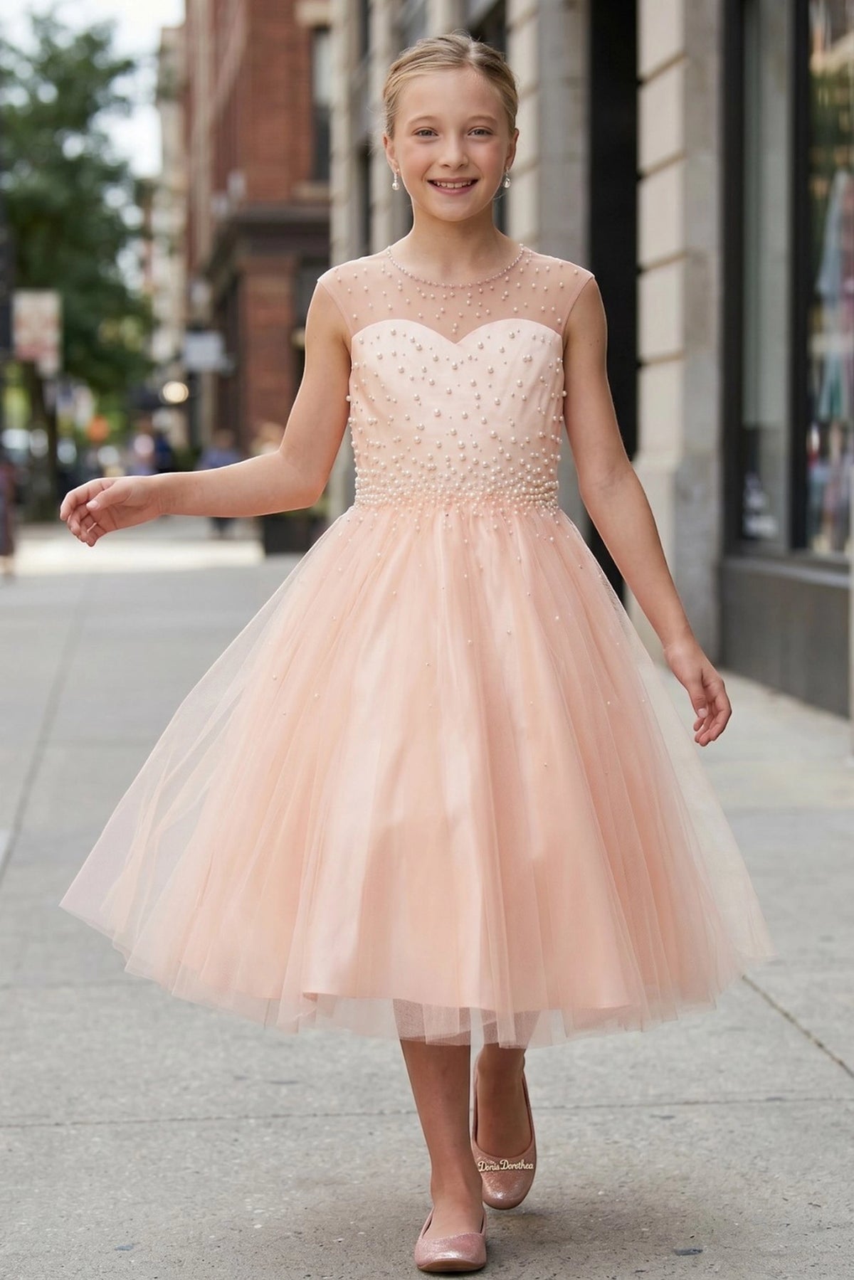 Detailed by a layered tulle skirt, the Blush kids party dress reveals its construction.