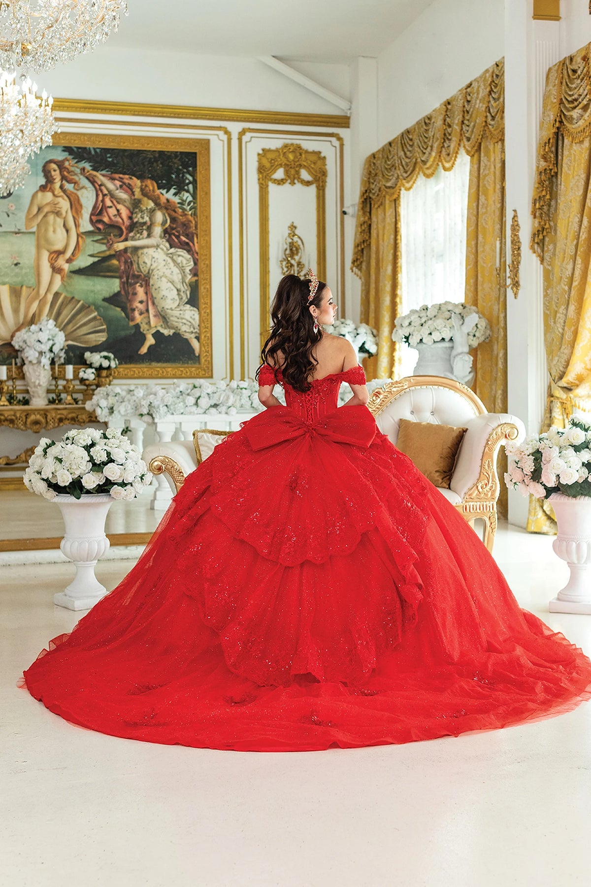 Back view of a Red quinceañera gown showing lace-up back, glitter tulle skirt, and floral appliqués
