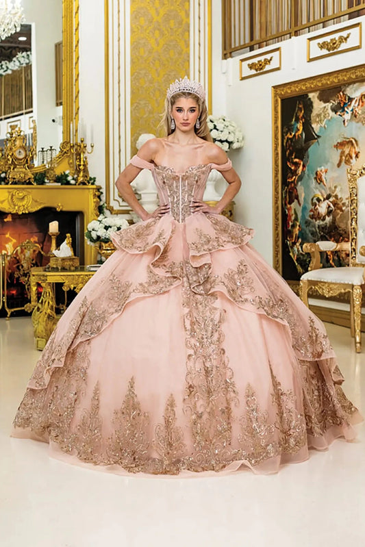 Front view of rose gold quinceañera ball gown with off-the-shoulder corset bodice, layered ruffle skirt, and ornate lace appliqués in a luxurious gold palace setting.
