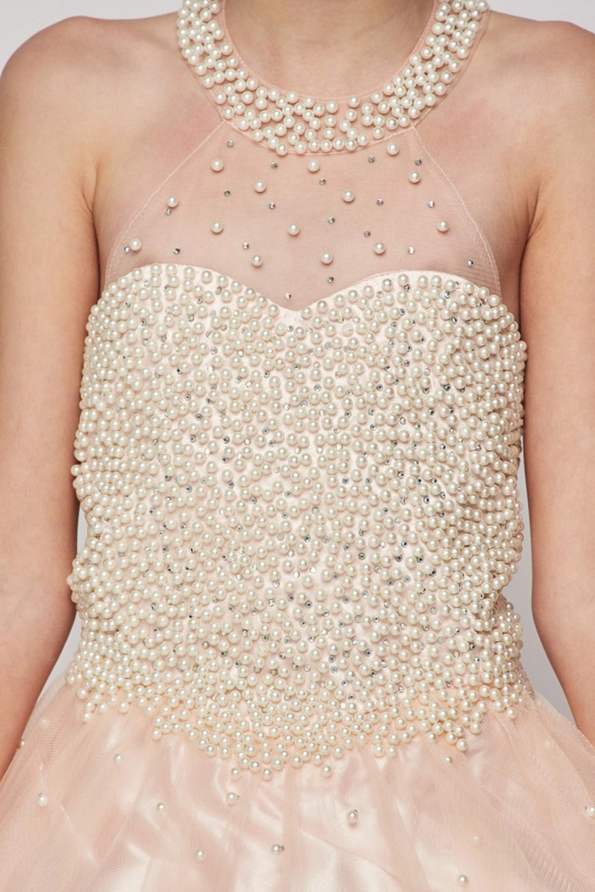 Showcasing pearls over the illusion halter bodice on the Blush mini quince dress.