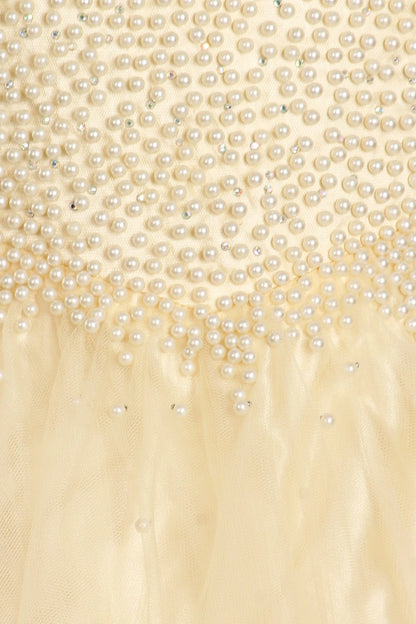 Showcasing pearls along the bodice and waist on the Champagne mini quince dress.