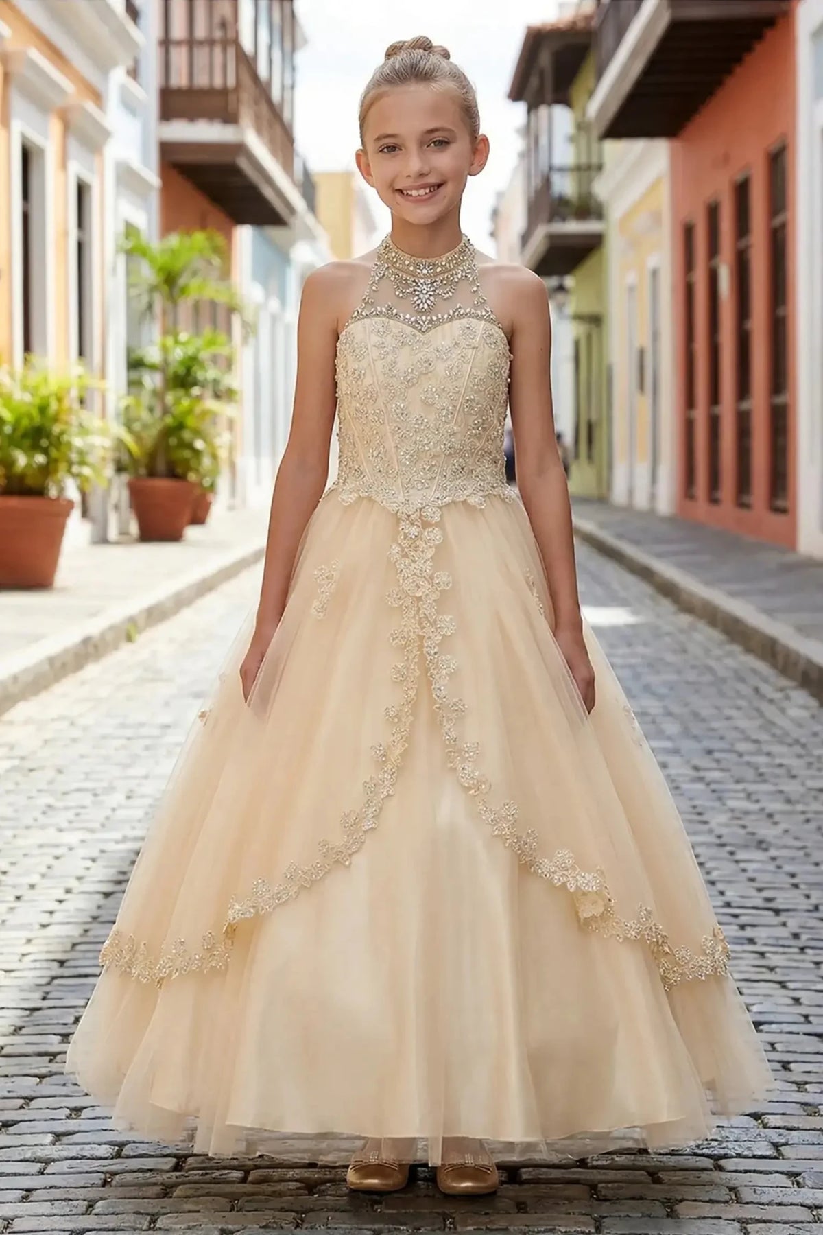 Champagne front view kids mini quinceañera mini quince dress with halter neck, rhinestones, pearls and layered tulle skirt.