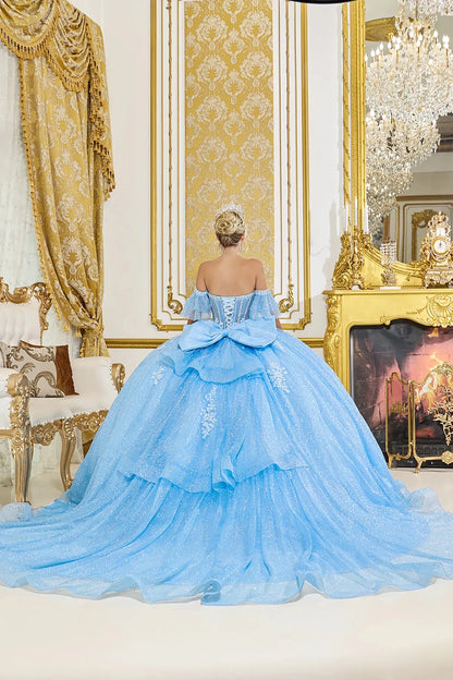 Back view: Light blue quinceañera ball gown back view featuring a lace-up corset, oversized layered bow detail, cascading ruffle skirt, and a flowing glitter tulle train