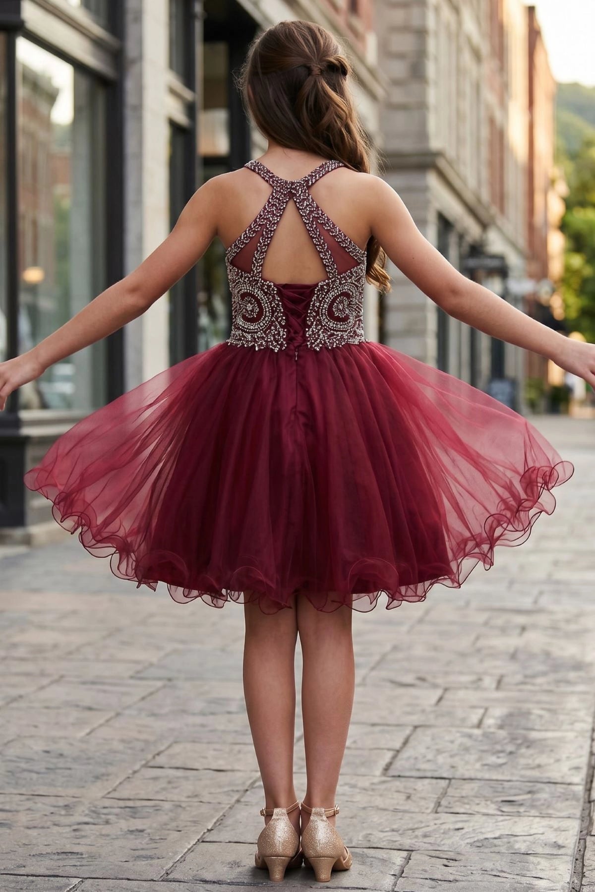 Finished details of crossed halter straps distinguish the Burgundy kids party dress.