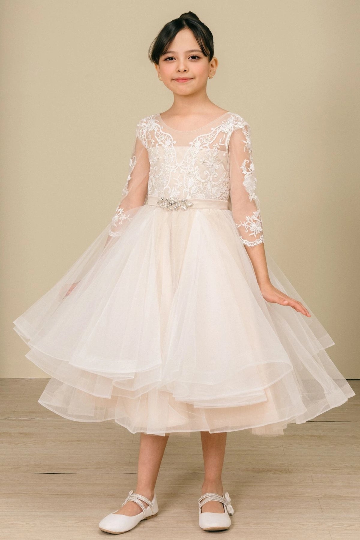 Showcasing with sheer floral lace sleeves, this Champagne kids party dress displays elegant detail.