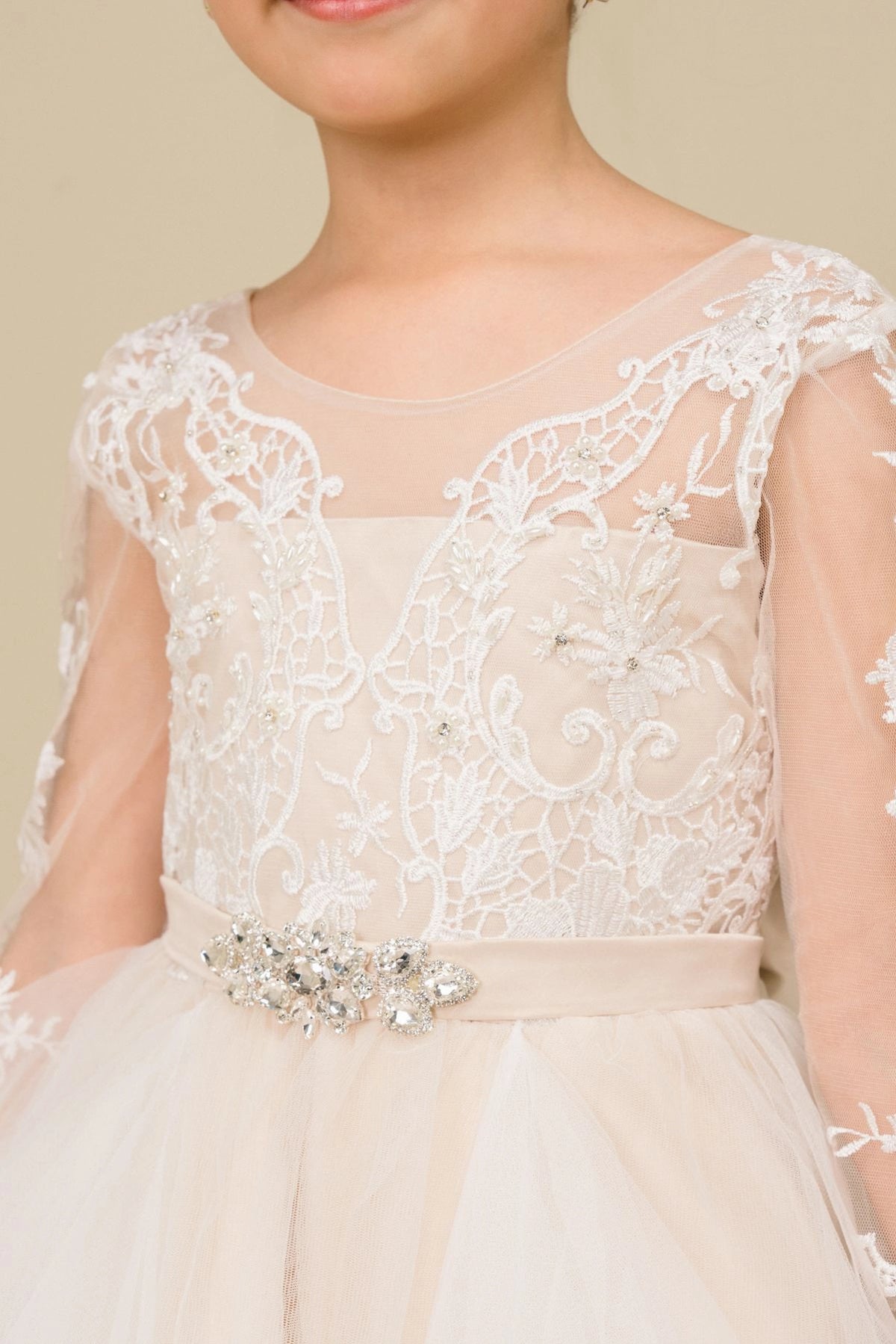 Featuring with sheer floral lace sleeves, this Champagne kids party dress displays elegant detail.