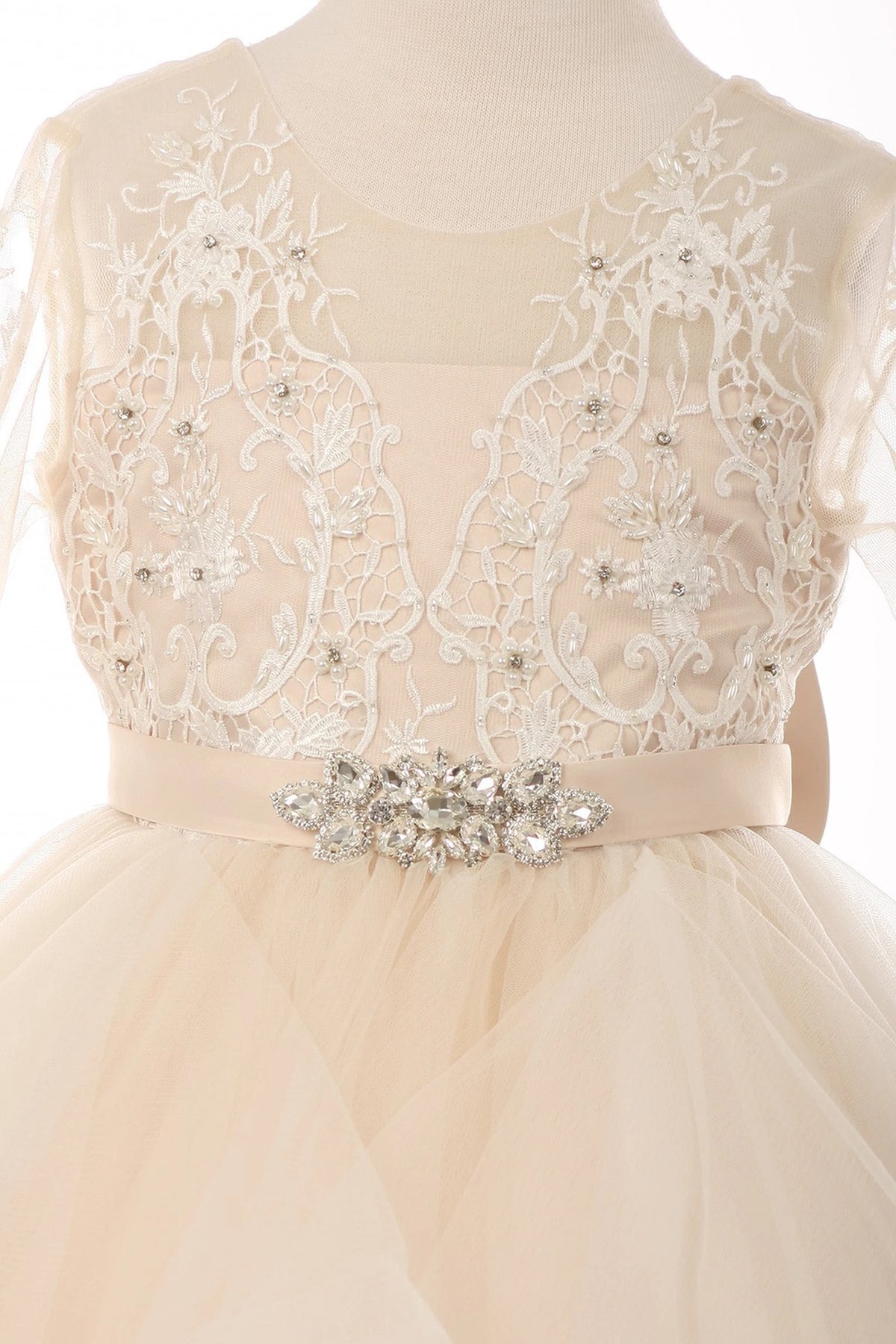 Trimmed by sheer floral lace sleeves, the Champagne kids party dress reveals its construction.