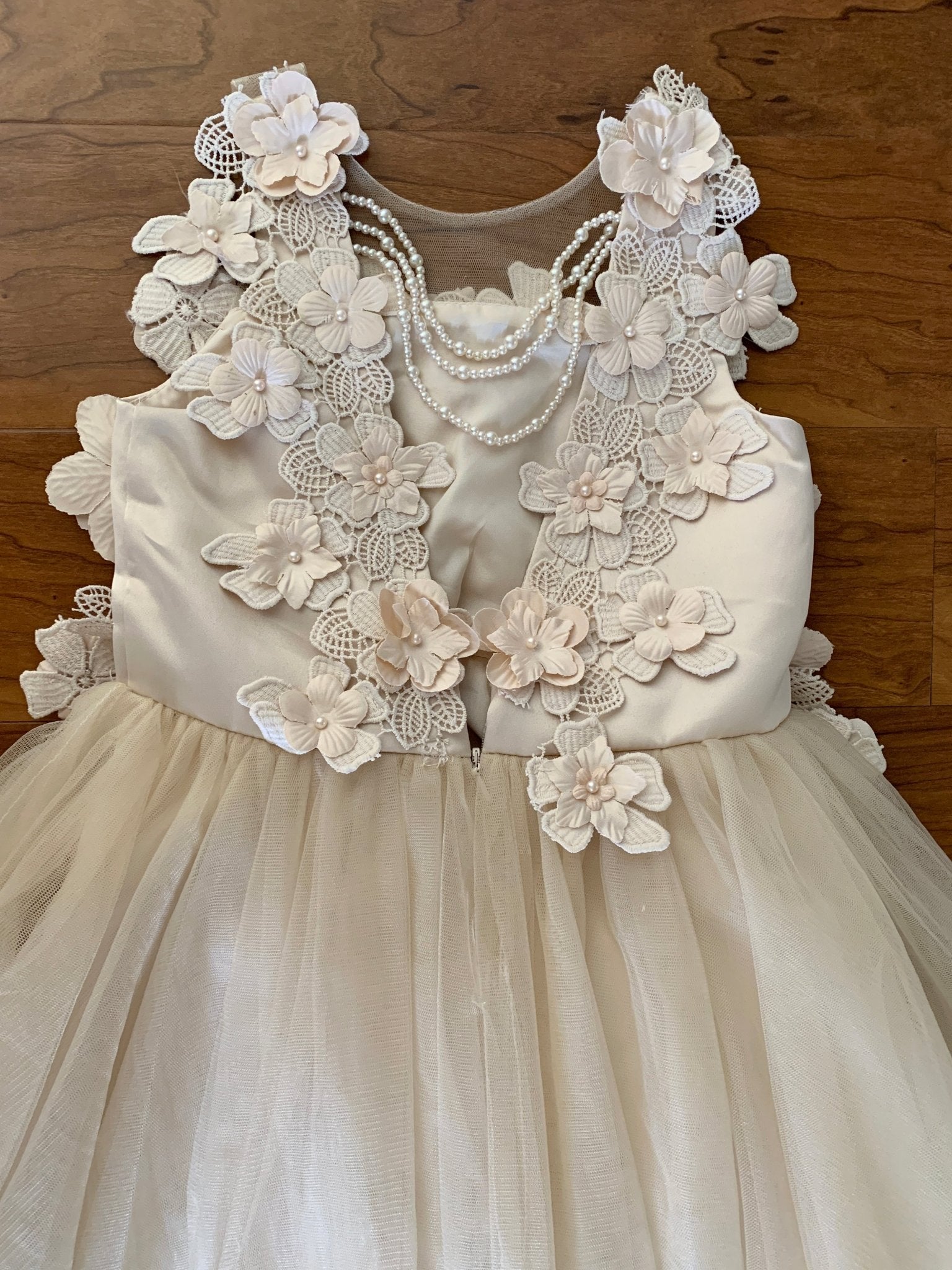 Close-up of Champagne High-Low Tulle flower girl dress with 3D Flower Lace Top Accentuated with Pearl Trim Dress.
