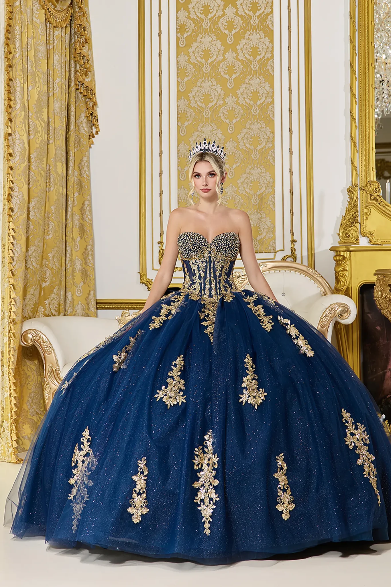 Front view of a woman wearing navy quinceañera dress featuring strapless beaded corset, gold embroidery, and glitter tulle skirt