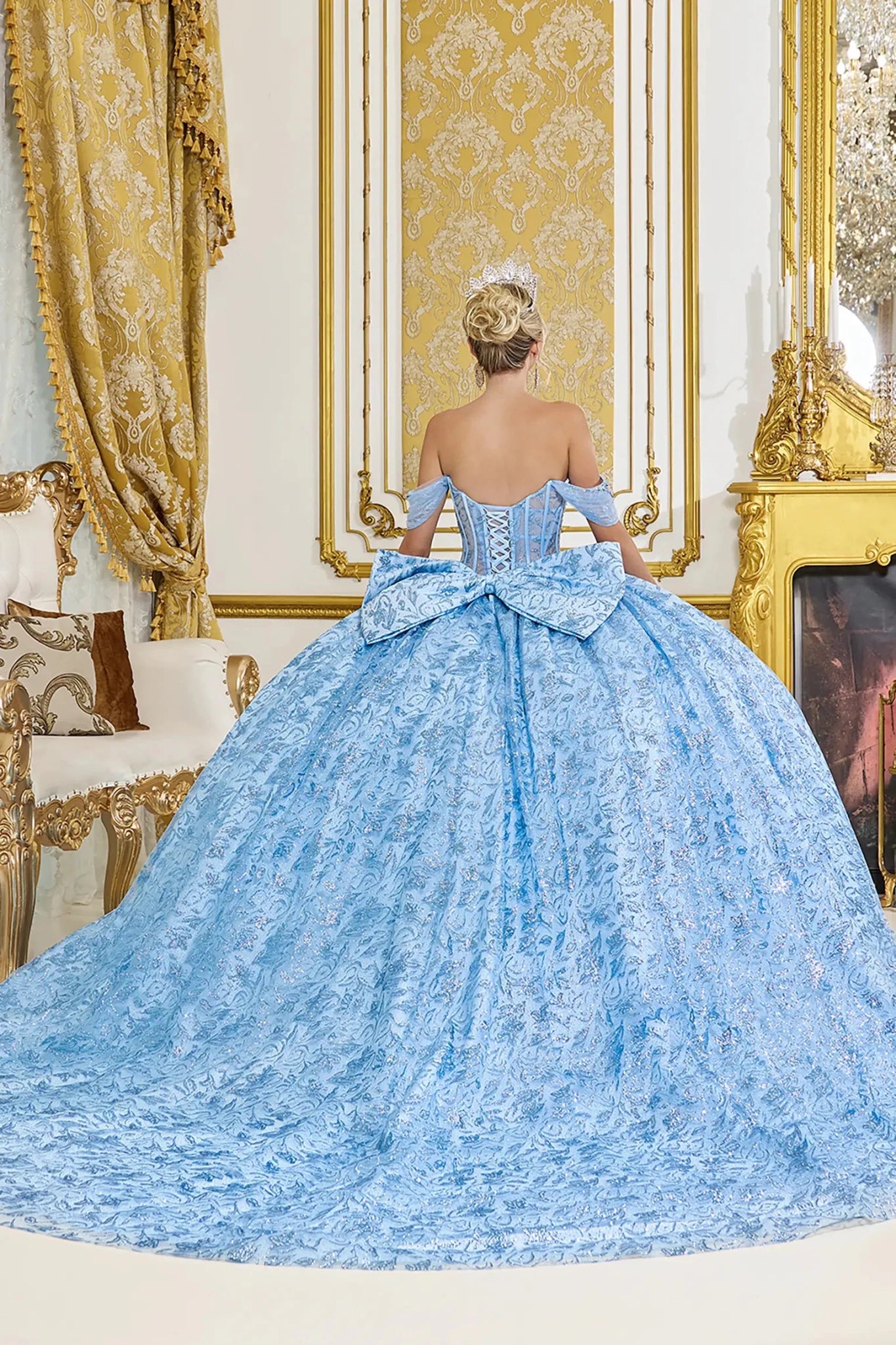 Bahama blue quinceanera ball gown back view showing lace up corset back, oversized structured bow, textured skirt fabric, and dramatic sweeping train