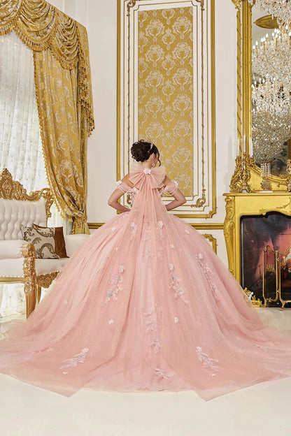Pink ball gown with floral embroidery in a luxurious room with gold decor.