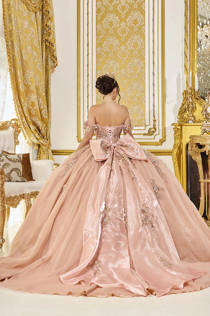Back view of rose gold quinceañera ball gown featuring a lace-up corset back, oversized satin bow, and long flowing train with delicate applique details