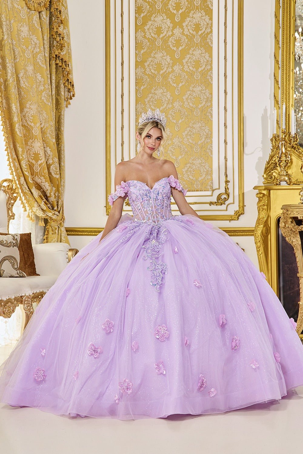 Woman in a lilac quinceanera ball gown standing in an ornate room with gold decorations.