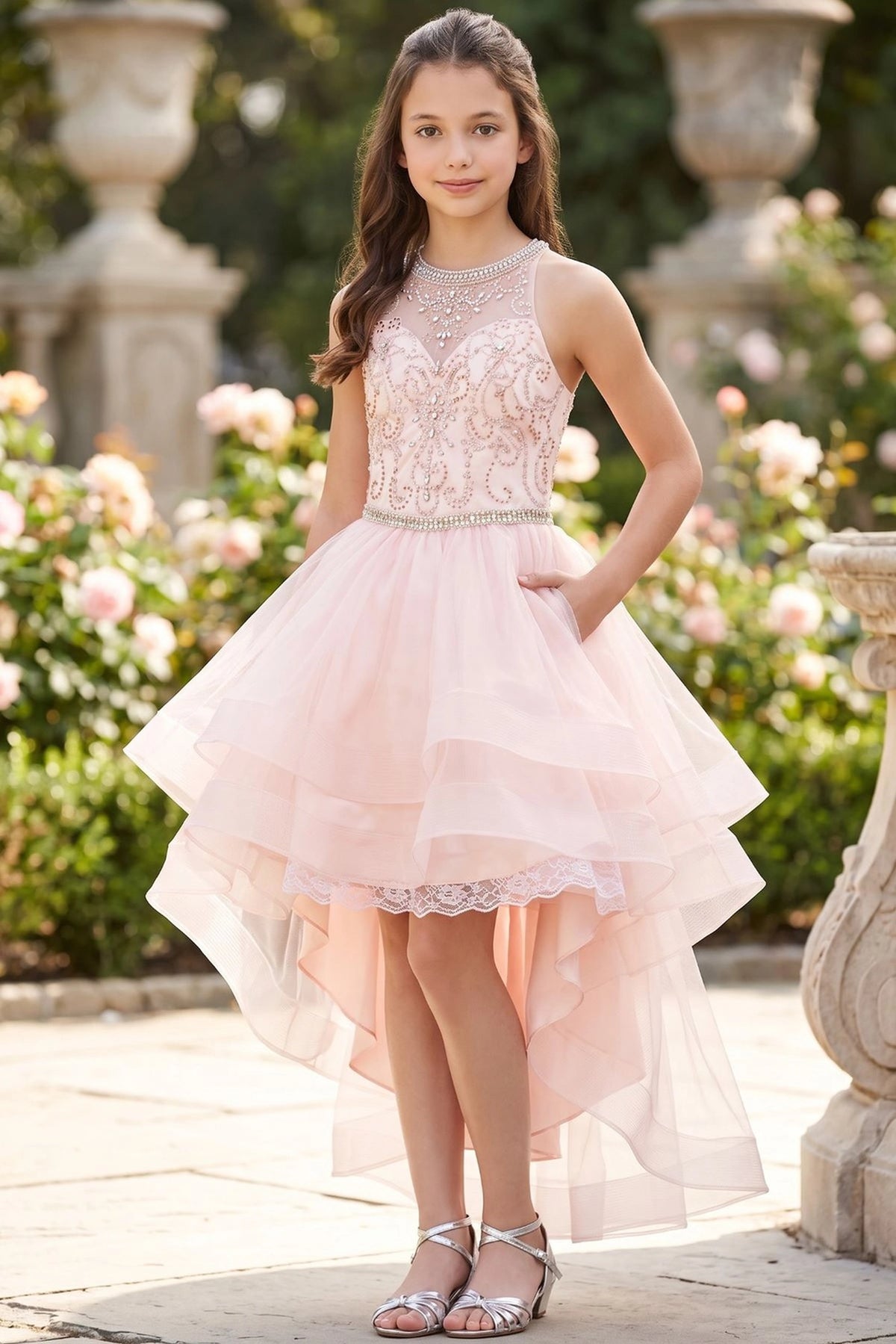 Accented a tiered high-low tulle skirt adds character to this Blush kids party dress.