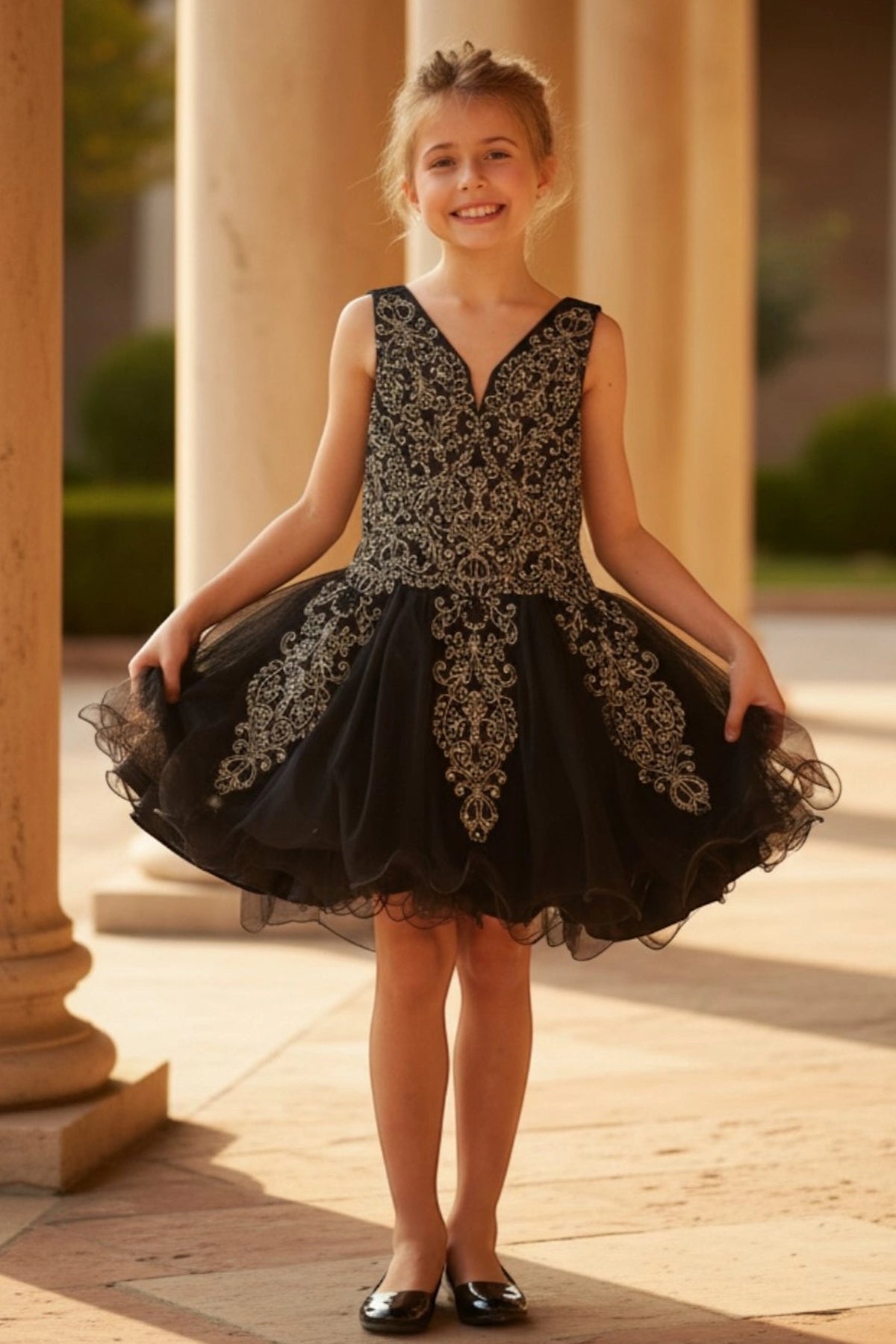 Accented a flared tulle skirt adds character to this Black kids party dress.