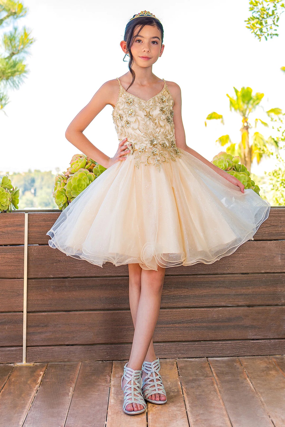 Designed details of a flared tulle skirt distinguish the Champagne kids party dress.