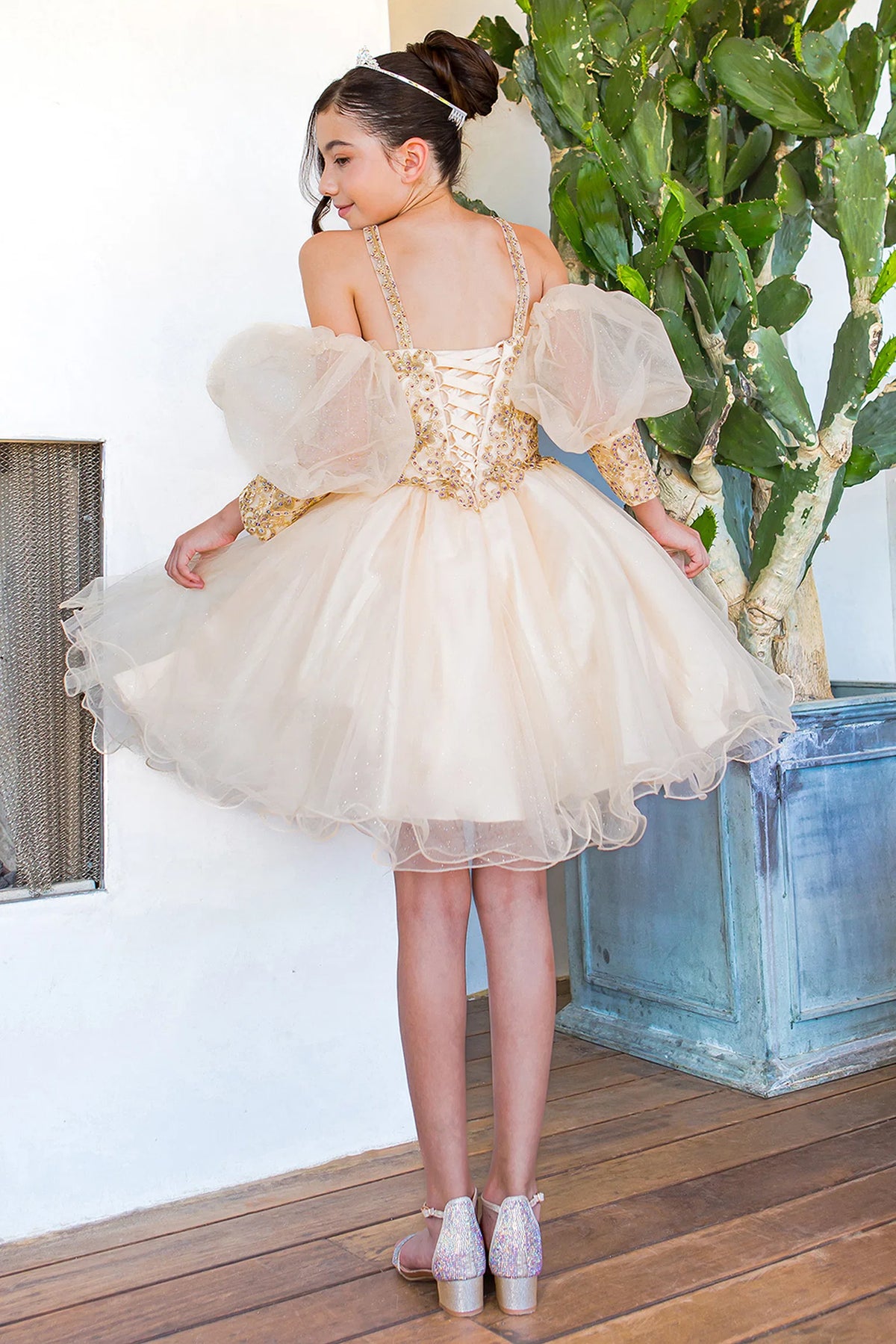 Styled with contrasting floral lace over the bodice, this Champagne kids party dress displays elegant detail.