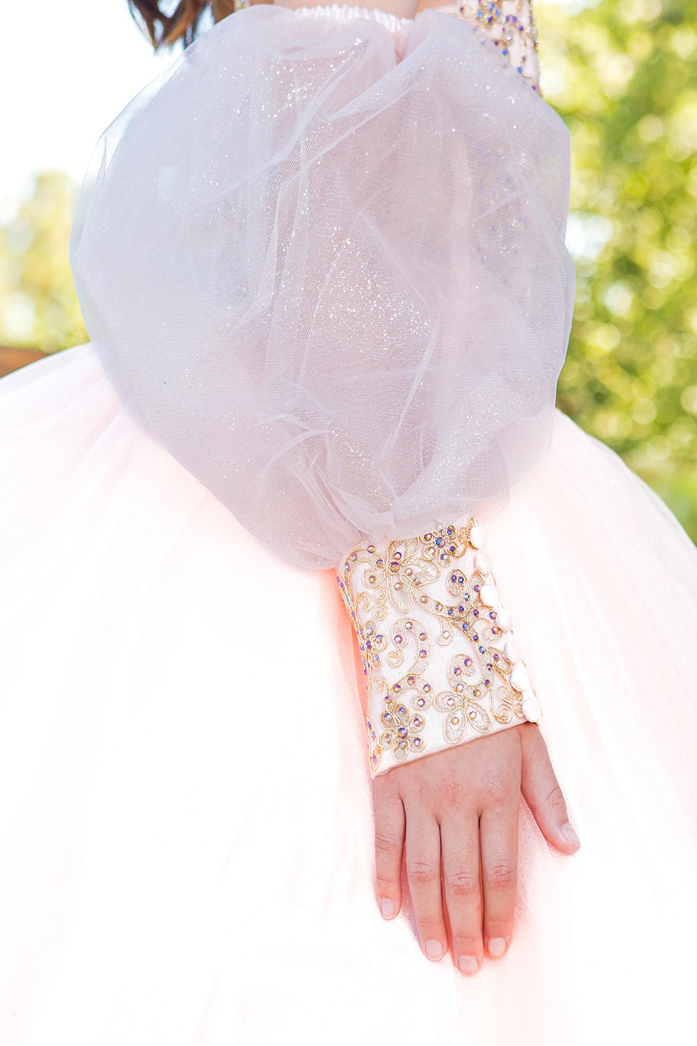 Close-up of blush mini quince dress detachable sheer puff sleeves glitter tulle and beaded applique