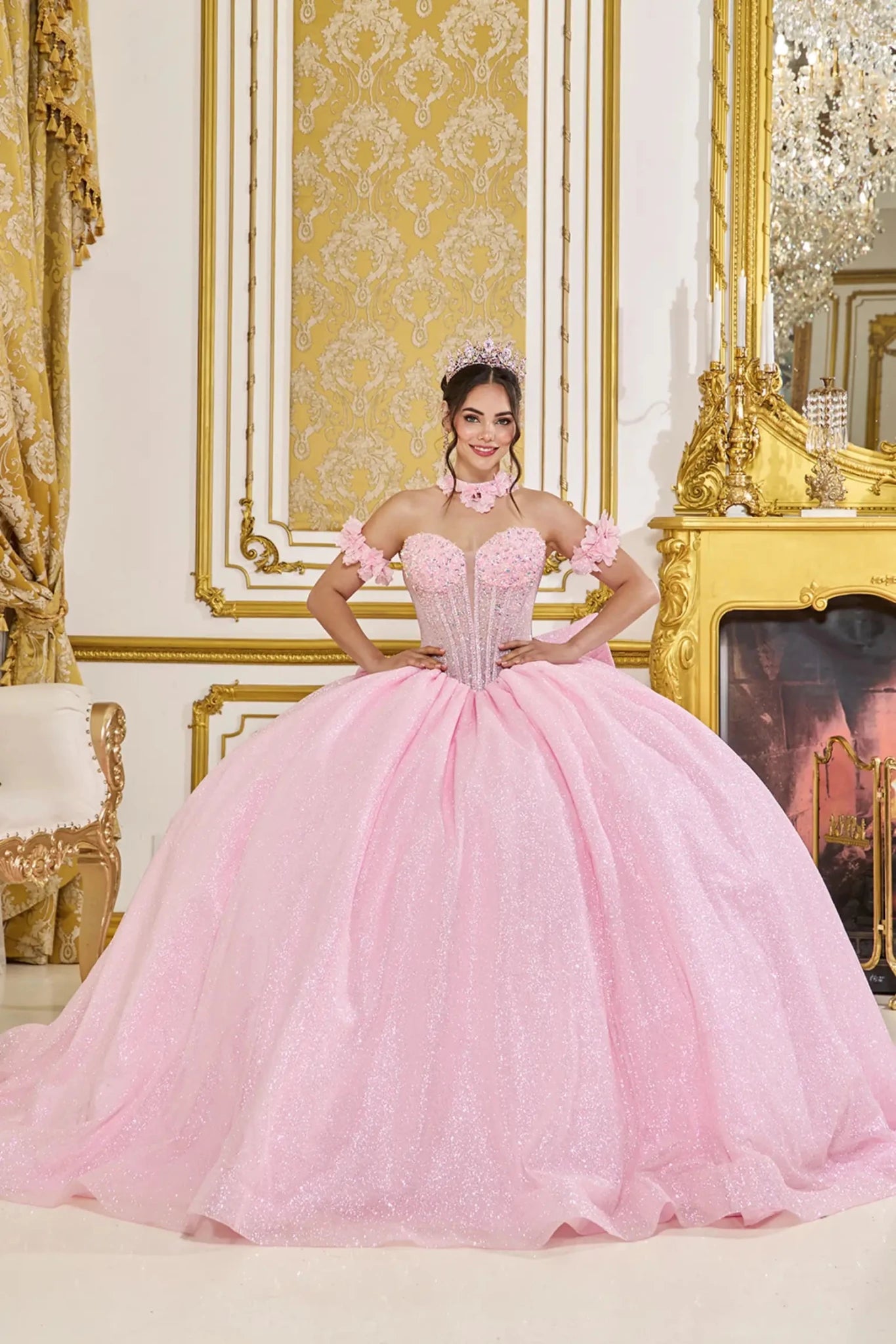 Front view of pink quinceañera ball gown with sweetheart corset bodice, off-the-shoulder floral straps, crystal embellishments, and full glitter tulle skirt.