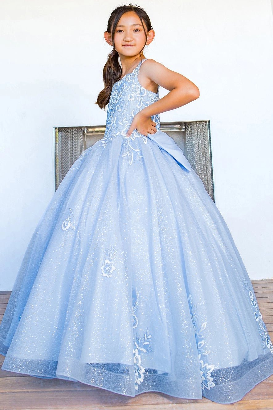 Displayed in a angled view, the Blue mini quince dress has floral lace appliques flowing onto the glitter tulle skirt.