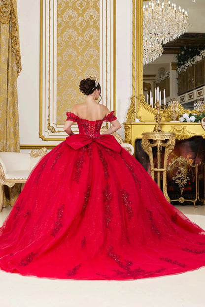 Red ball gown with intricate details in a luxurious room with gold accents.