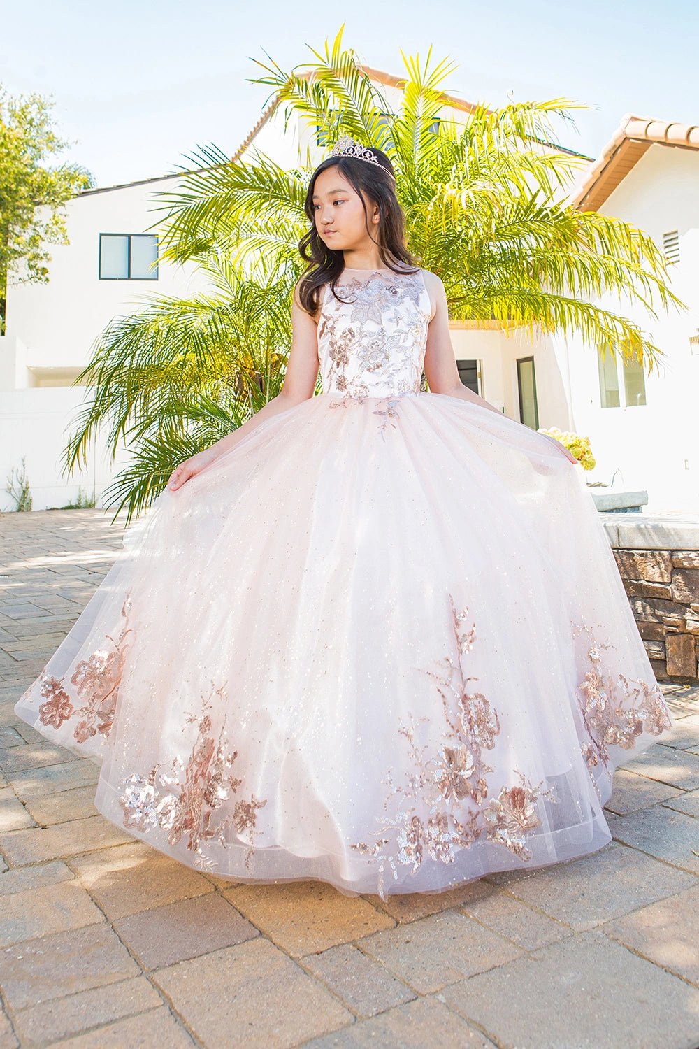 Shown in a front view, the Blush mini quince dress has sleeveless floral embellished bodice and full glitter tulle skirt.