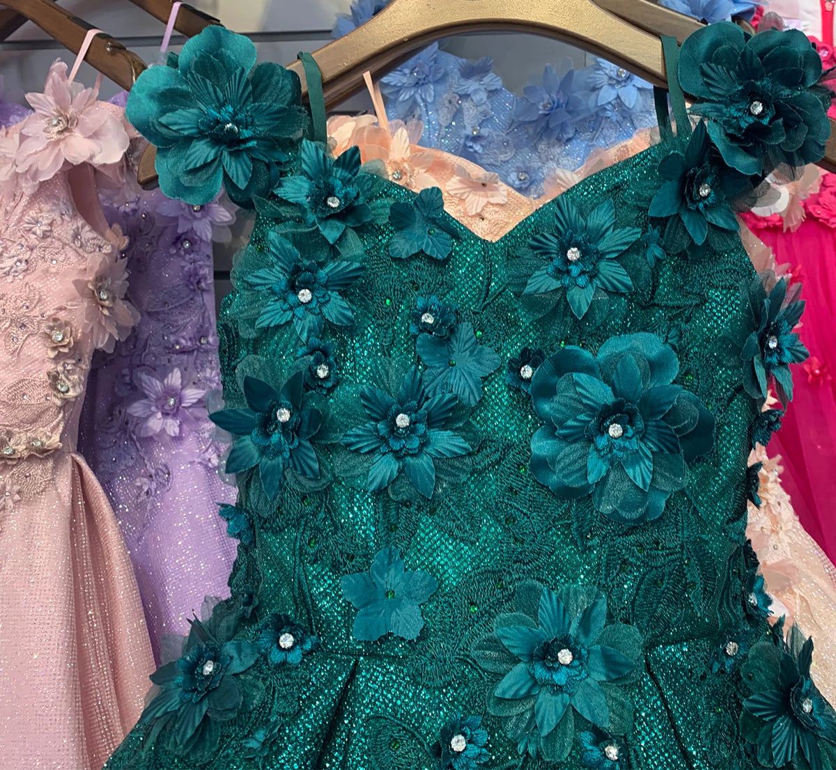 Teal flower girl dress with floral embellishments.