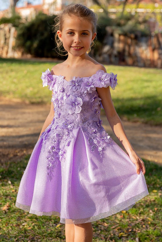 Young girl standing front-facing in lilac off-the-shoulder flower girl dress with 3D floral appliqué bodice and shiny layered tulle skirt
