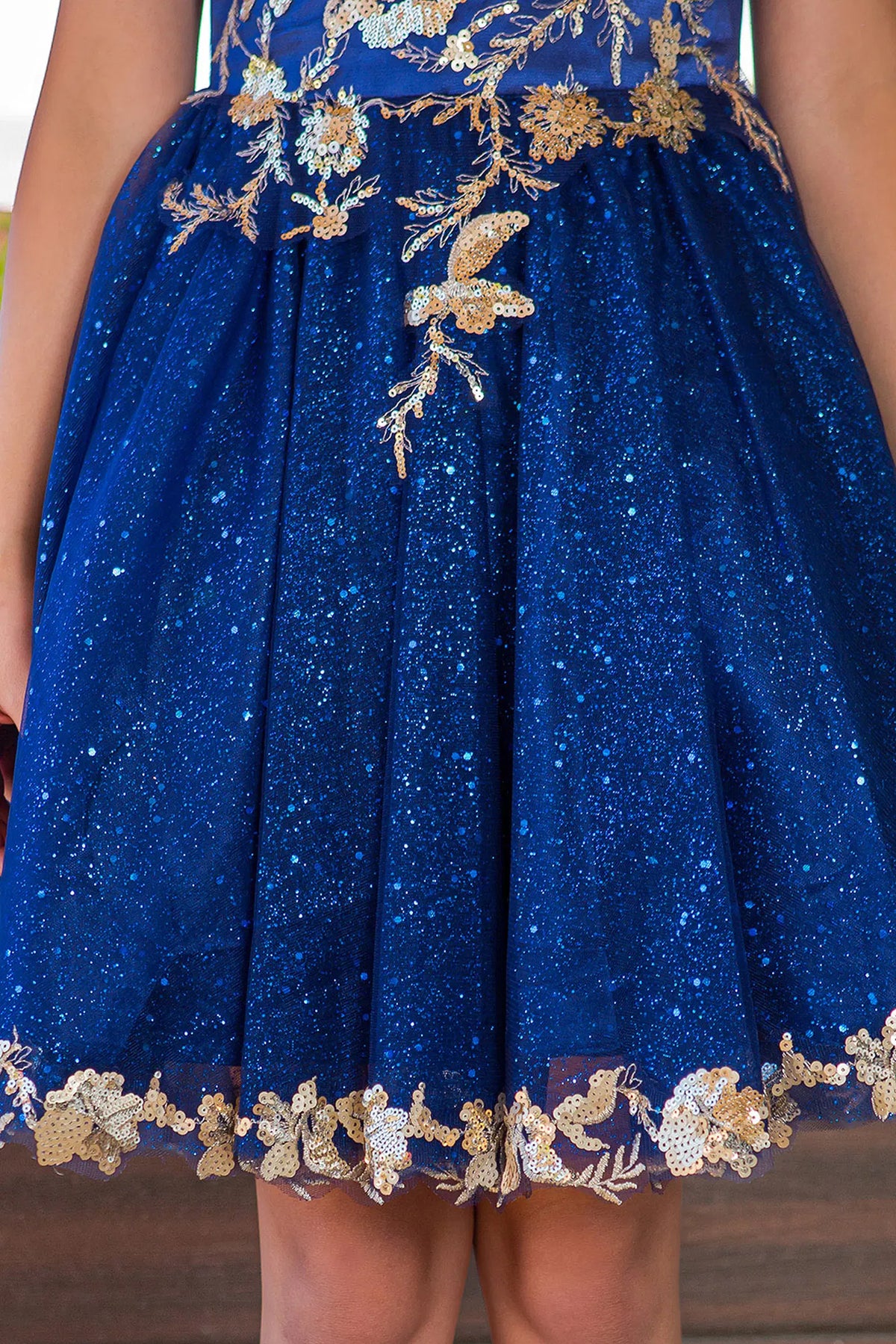 Layered with contrasting lace along the hem, this Navy kids party dress displays elegant detail.