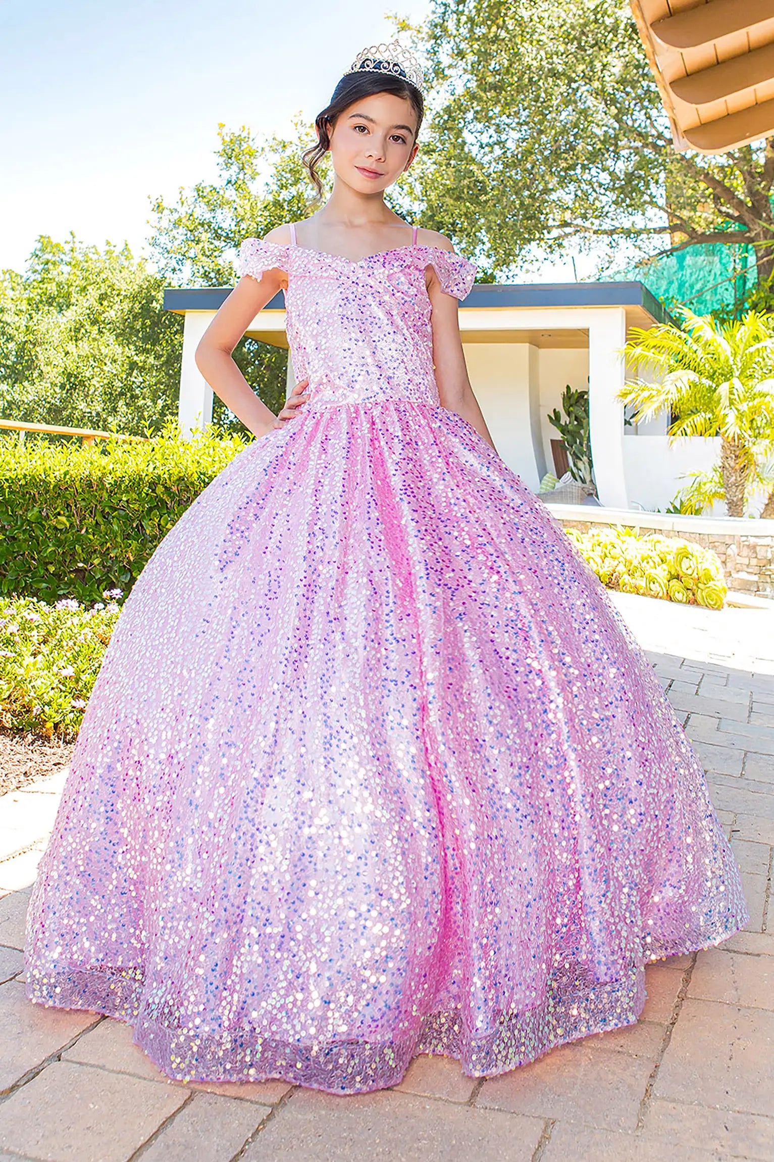 Girl standing front-facing in blue mini quinceañera dress with sparkling fabric, 3D flower puff print, and flowing A-line skirt with shimmer accents