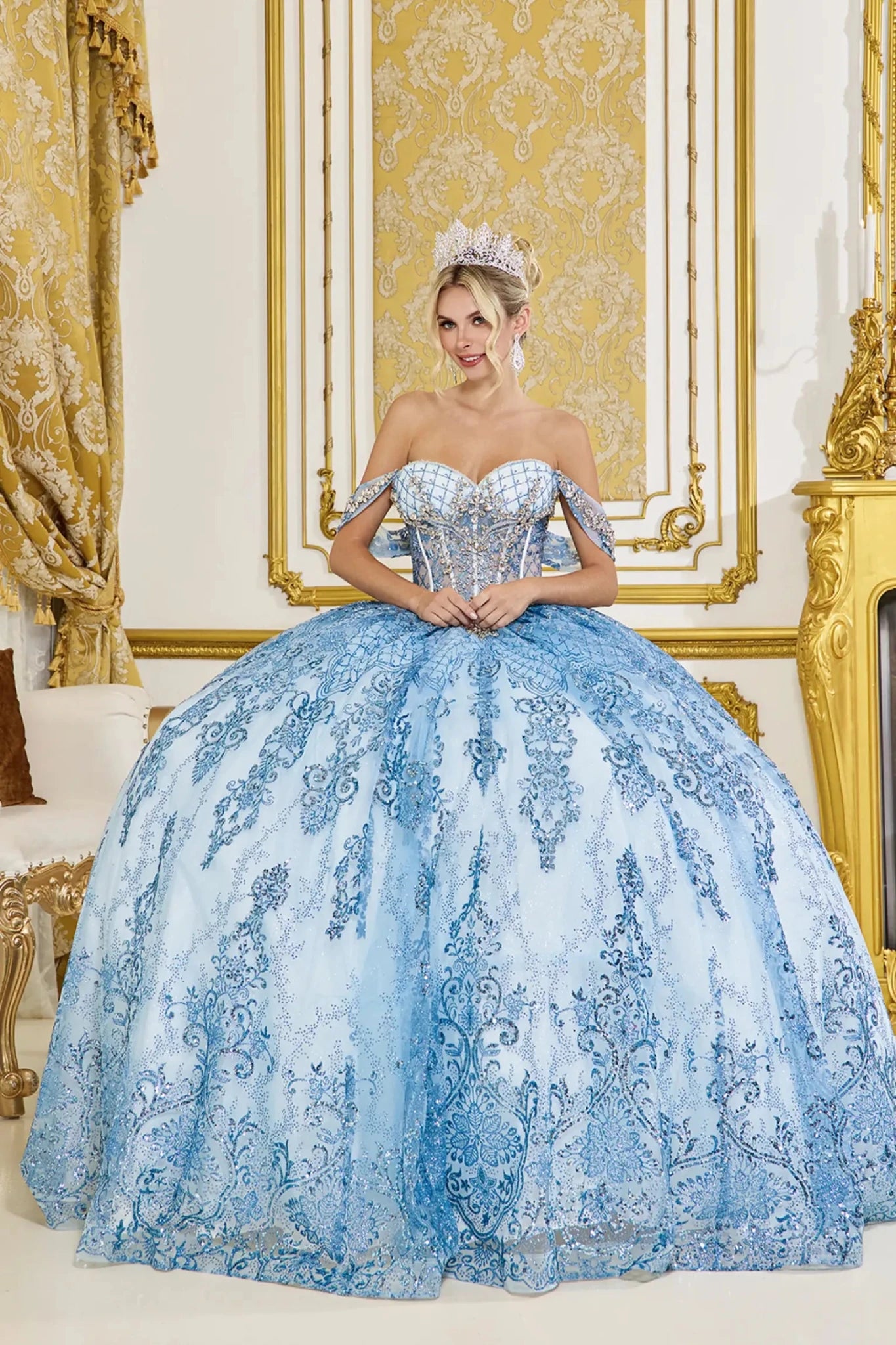 Front view of dusty blue quinceañera ball gown with off-the-shoulder neckline, sweetheart corset bodice, and full tulle skirt adorned with ornate lace embroidery.